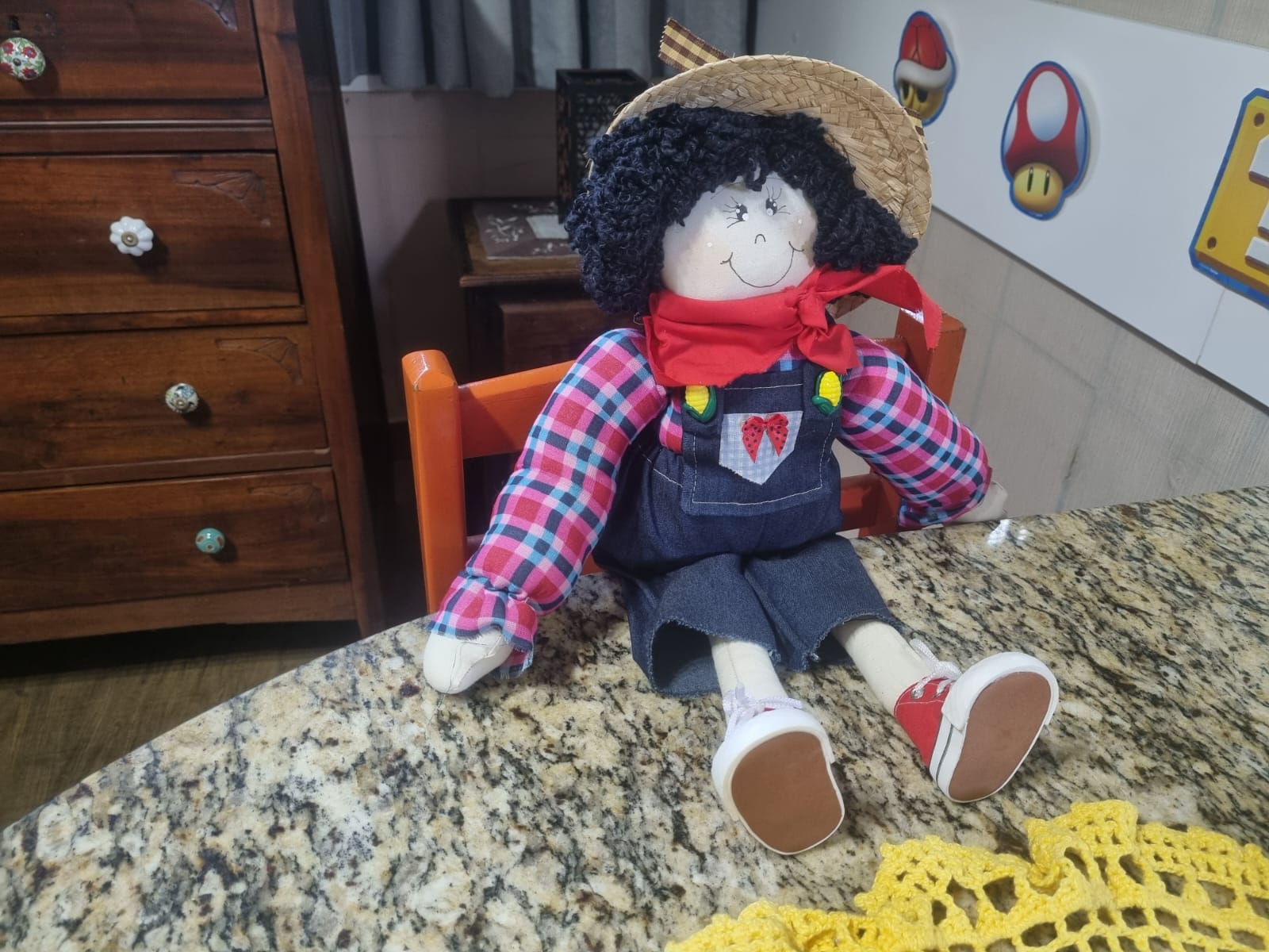 Boneco artesanal caipira com chapéu de palha e macação jeans